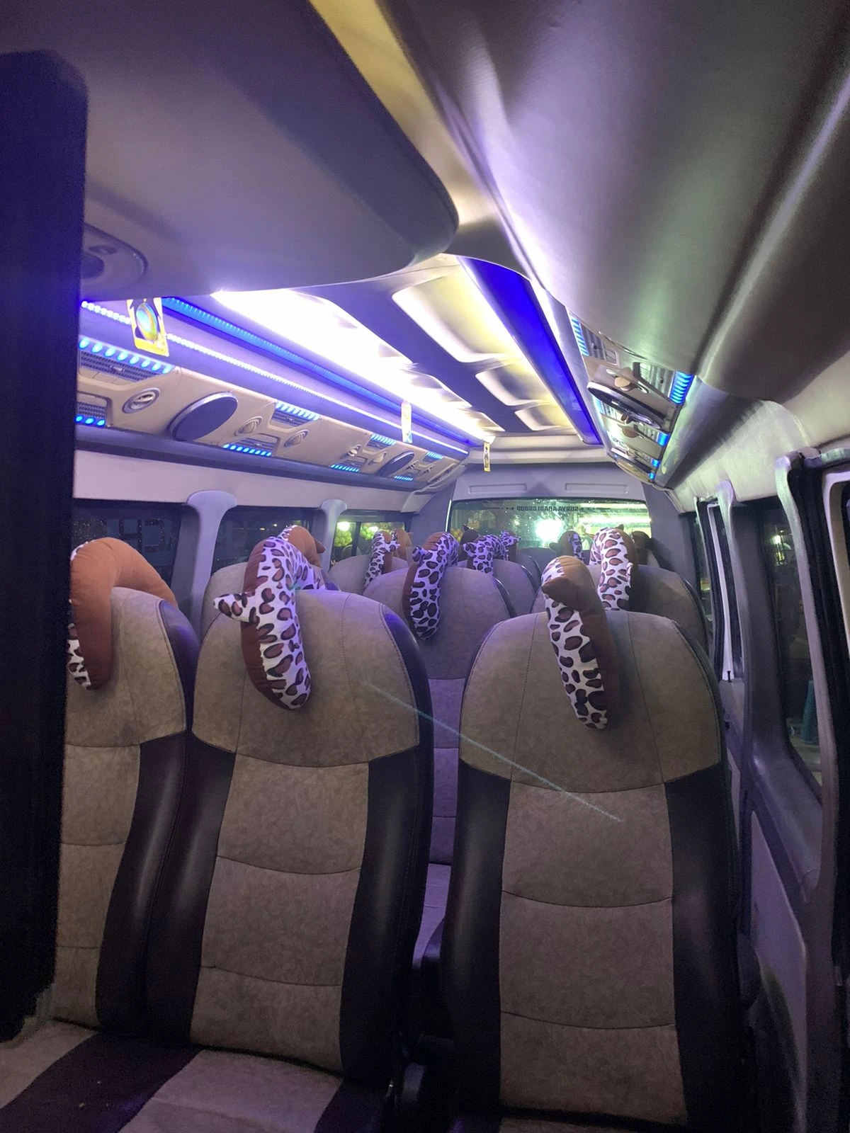 Kursi penumpang Elf Long dengan sandaran kepala motif macan tutul dan lampu LED biru